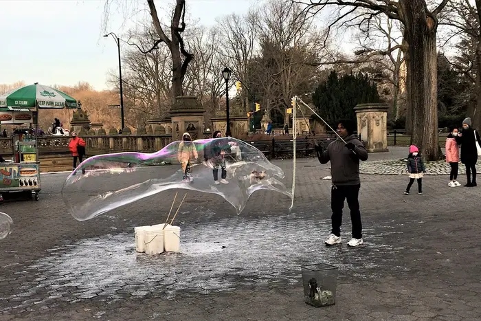 A man making a huge bubble in Central Park
